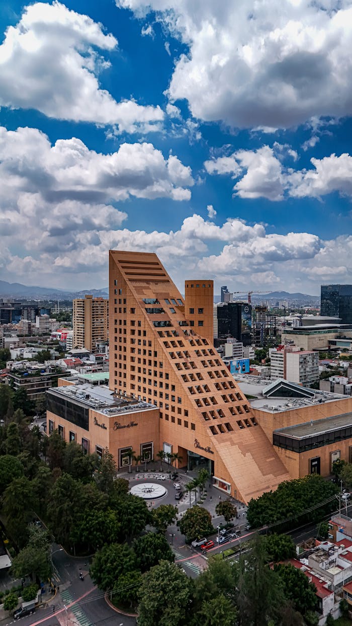 Aerial shot of an iconic building in Mexico City showcasing modern architectural design against a vibrant urban backdrop.